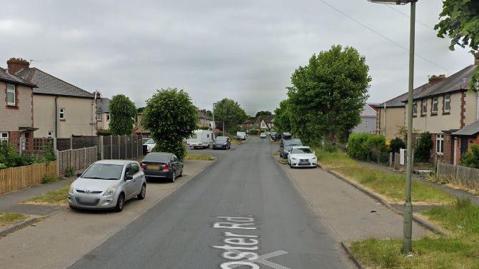 Gloster Road, Woking in a google street view image with cars parked along the edge of the street