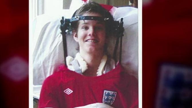 George Dowell in a wheelchair when he was younger wearing an England top