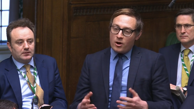 Olly Glover, the Liberal Democrat MP for Didcot and Wantage, speaking at Prime Minister's Questions. He is wearing a blue suit, shirt and tie.