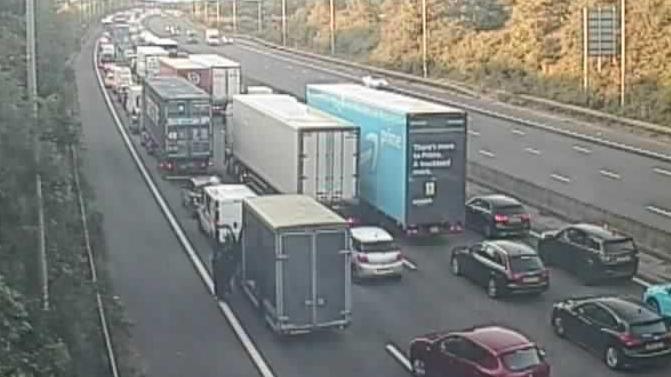 A traffic camera showing a four-lane motorway full of cars at a stand still.