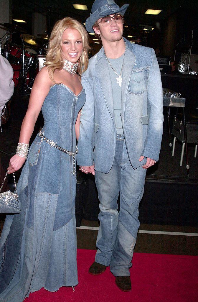 Britney Spears and Justin Timberlake appear on a red carpet in 2001. They are both wearing full denim outfits in a very famous look that went on to define their relationship together.
