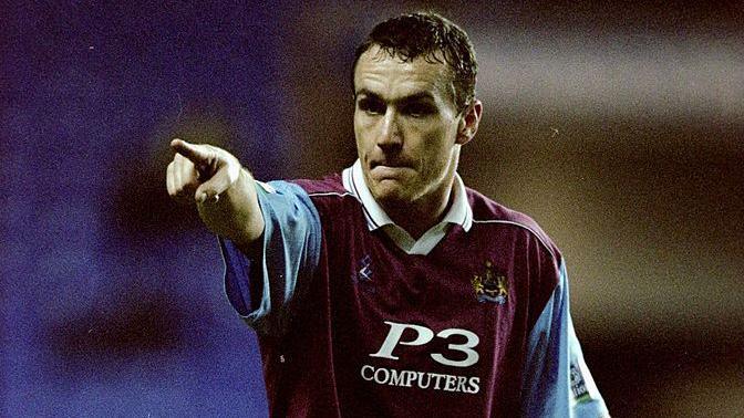 Micky Mellon points into the distance in a Burnley kit.