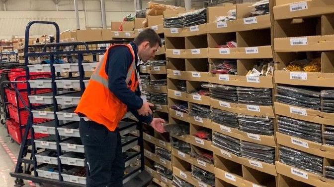 A warehouse worker sorts through stock at Kammac’s Wavertree site in Liverpool