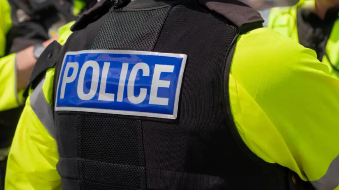 Police officers in flak jackets and yellow bibs