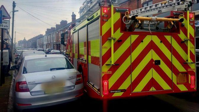 A close call with a fire engine trying to get past a silver car