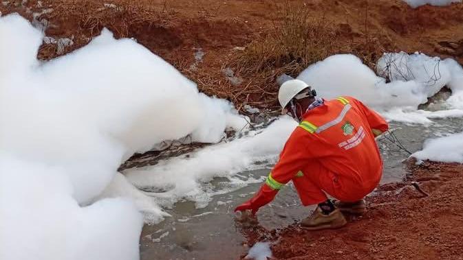 Official in Nigeria collects sample from foamy substance on Abuja-Kaduna highway