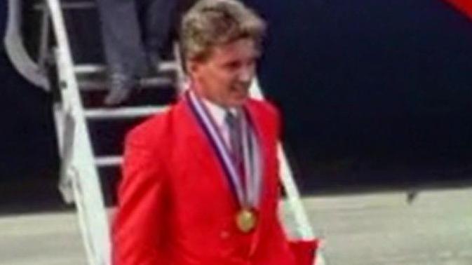 Colin Mallett with his gold medal in 1990 at an airport