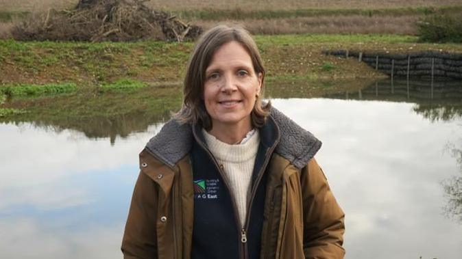 Jilly McNaughton standing in front of a restored pond