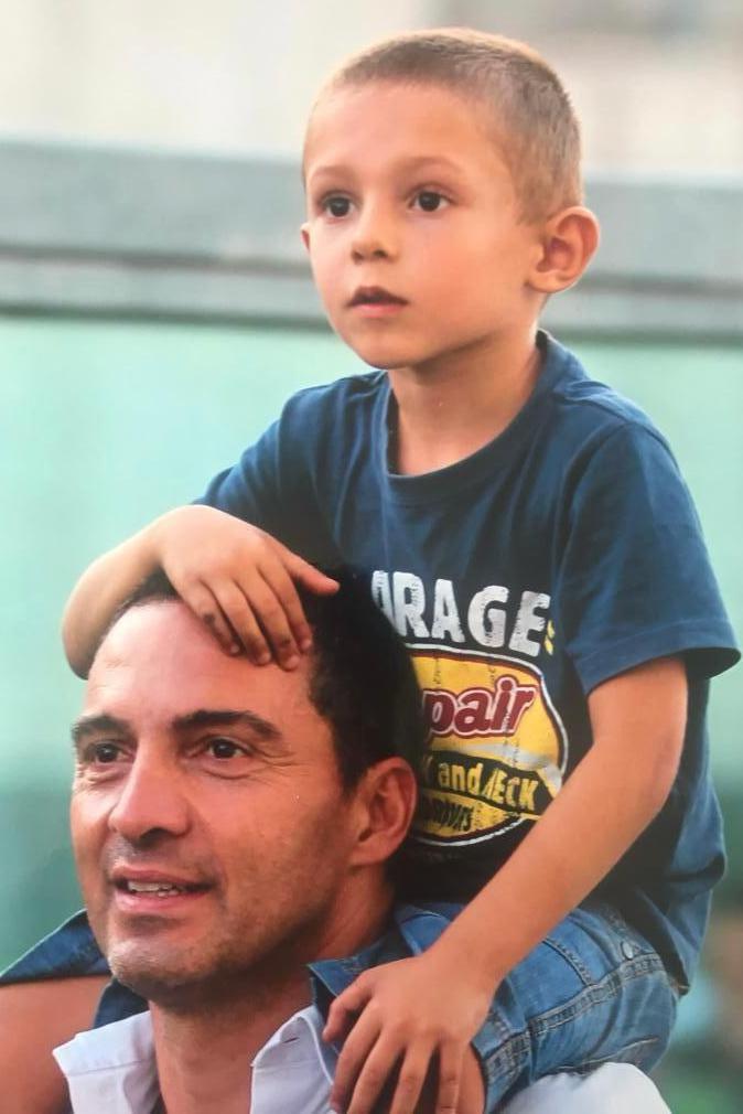Kimi Antonelli, aged about four or five, sat on his dad's shoulders
