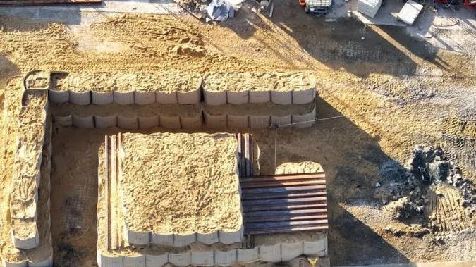 Huge bags of sand built up into walls which surround a temporary sand bunker