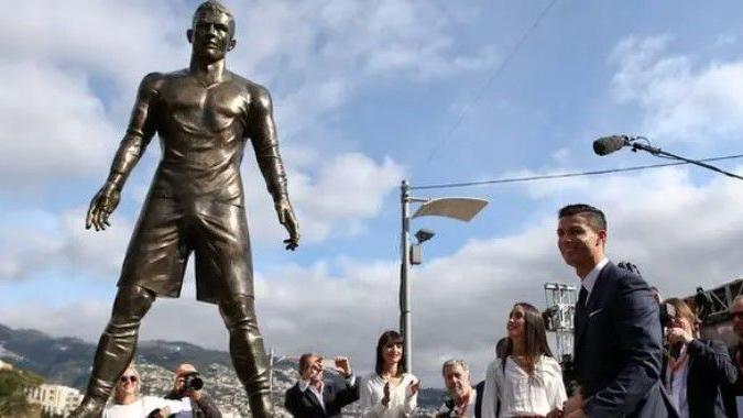 Cristiano Ronaldo stands next to a statue of himself
