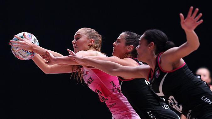 Sophie Kelly of London Pulse reaches for the ball with Jess Shaw and Celena Appleby-Prince of Loughborough Lightning during Netball Super Cup