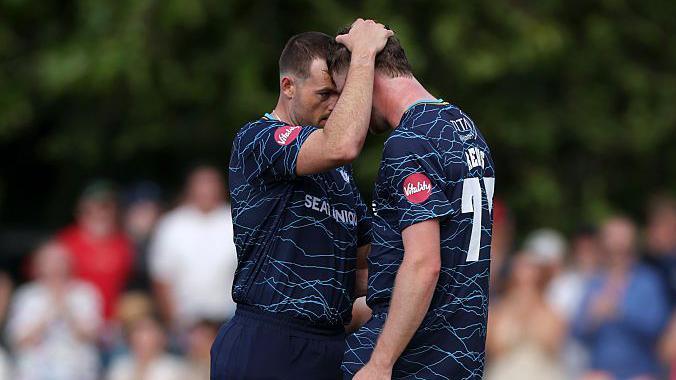 Yorkshire's Matthew Revis in all blue is consoled by Dan Moriarty after narrowly failing to score the winning runs off the last ball at Derbyshire