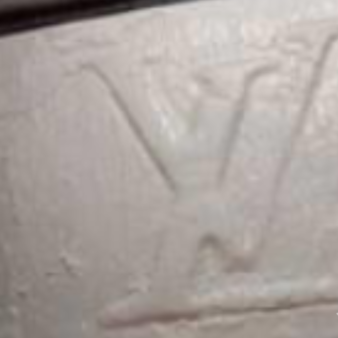 A police picture of a slab of white drugs - cocaine - with an LV logo on it