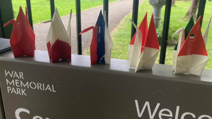 Paper origami cranes on a sign in War Memorial Park