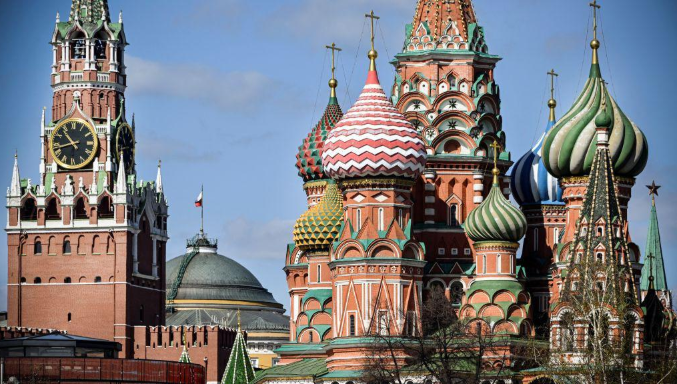 The Kremlin's red brick Spasskaya tower and St. Basil's cathedral in downtown Moscow