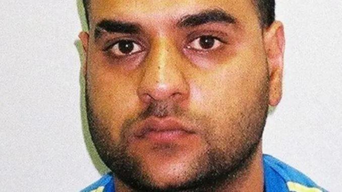 A police mugshot of Mohammed Ali Sultan, who is wearing a blue and yellow top.