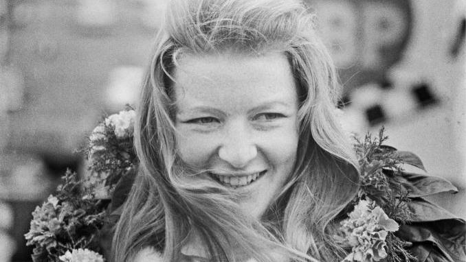 Gillian Fortescue-Thomas pictured in black and white with a motor racing wreath around her neck