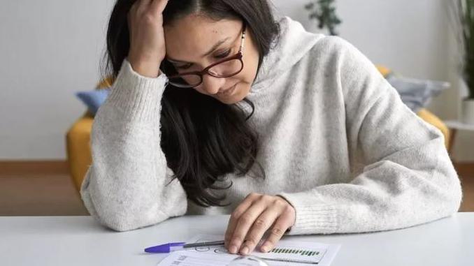 A woman looking anxiously at paperwork