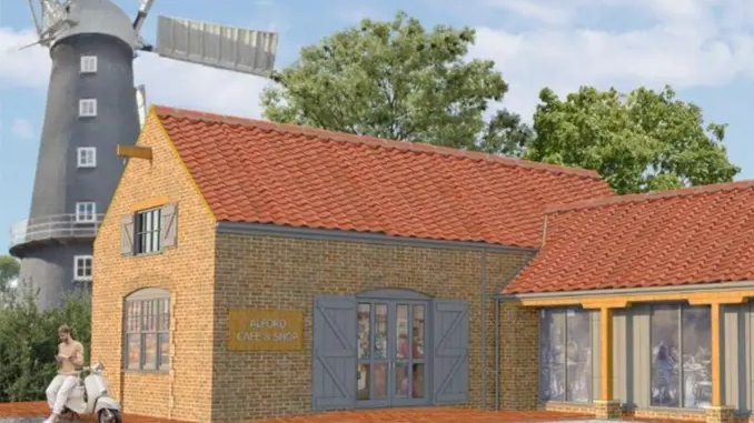 An artist's impression of the plans for the windmill grounds, with smart outbuildings housing cafe and retail spaces, with the restored windmill in the background. 