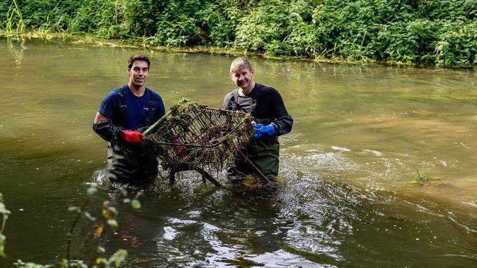 Councillor Alister Brady (right) and another volunteer fishing a trolley out of the River Stour