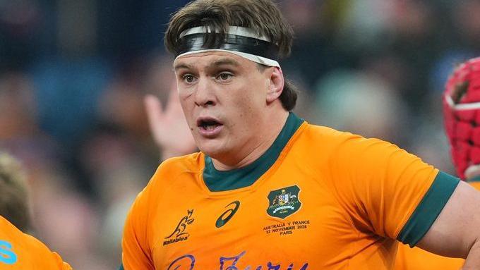 Tom Hooper wearing a headband and Australia shirt, looking on open-mouthed