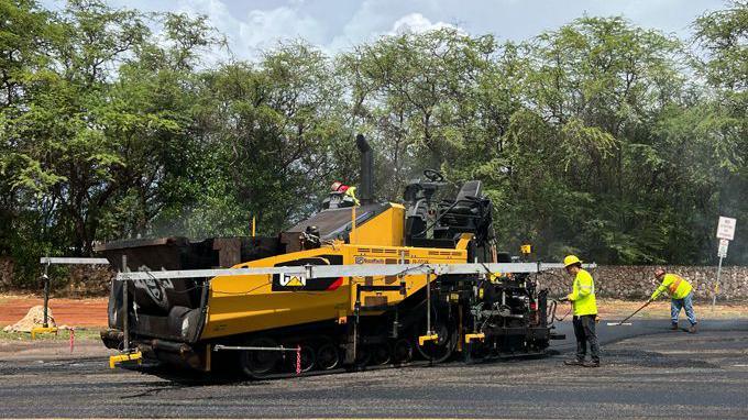 A crew works on paving a section of road along Ewa Beach to test different plastic-asphalt mixtures