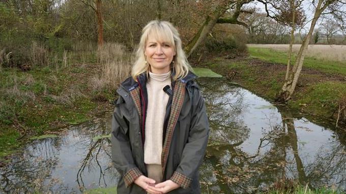 Emma Gray standing by a recently restored pond on her farm at Panfield, near Braintree