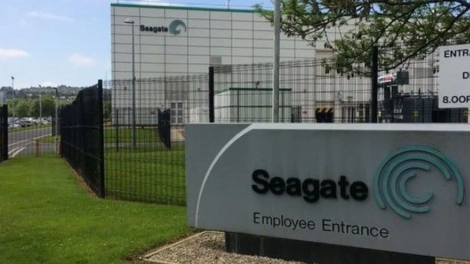 Shows a factory with sign saying Seagate Employee entrance