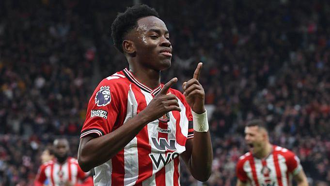 Simon Adingra pointing in the air after scoring against Leeds