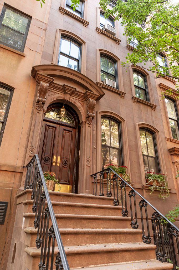 The outside of 66 Perry Street shows brown steps leading up to a brownstone