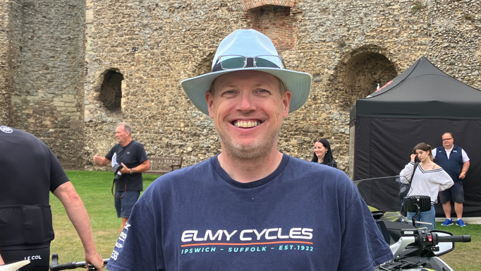 A head and shoulders image of Bike shop owner Steve Grimwood. He is wearing a T-shirt with Elmy Cycles written on it and a hat. He is smiling.