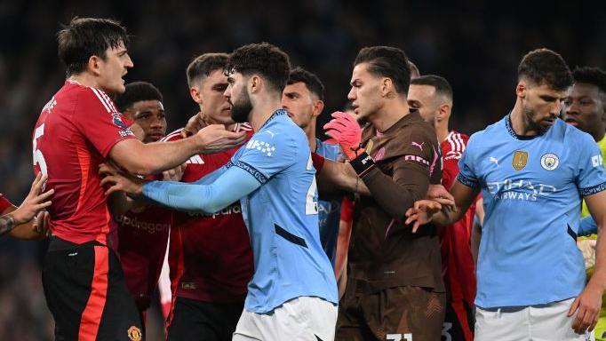 Manchester City and Manchester United players clash in the derby at Etihad Stadium