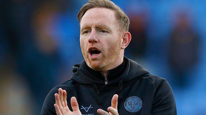 Shrewsbury Town boss Gavin Cowan claps his hands in encouragement 