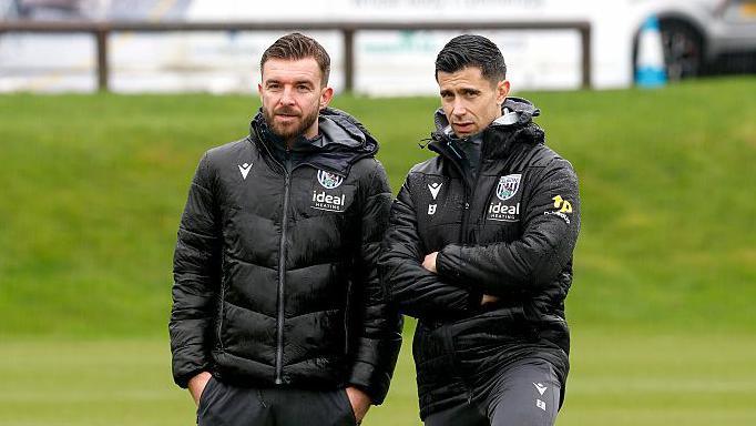 James Morrison stands next to Eric Ramsay as they watch a training session