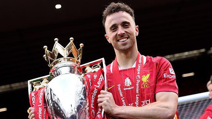 Diogo Jota holding the Premier League trophy while playing for Liverpool in May