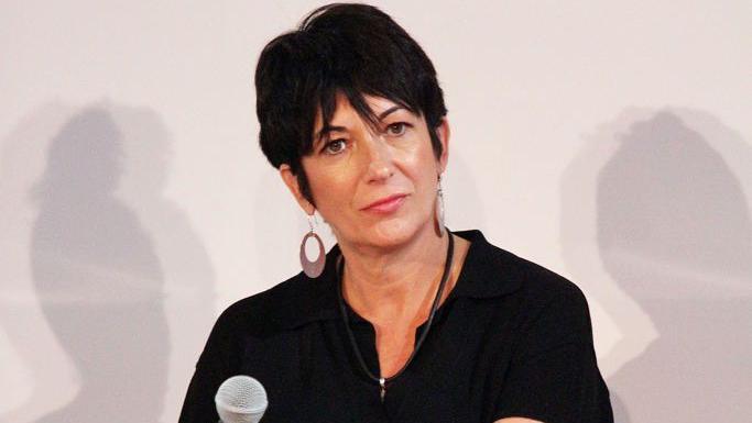 A photo of Ghislaine Maxwell from an event in 2013. She is wearing a black dress with earrings, and is sporting a black pixie haircut.