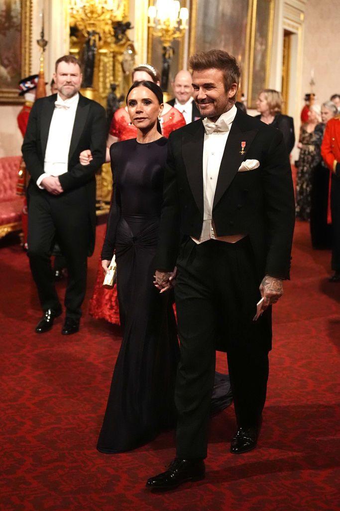 David Beckham (R) and Victoria Beckham (L) arrived for the banquet hand-in-hand. They are walking, wearing formal evening wear