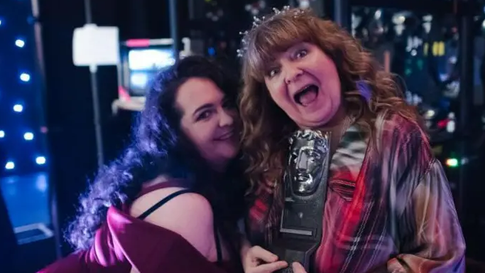 Janey Godley, right, holding an award, with her daughter, Ashley Storrie, left.