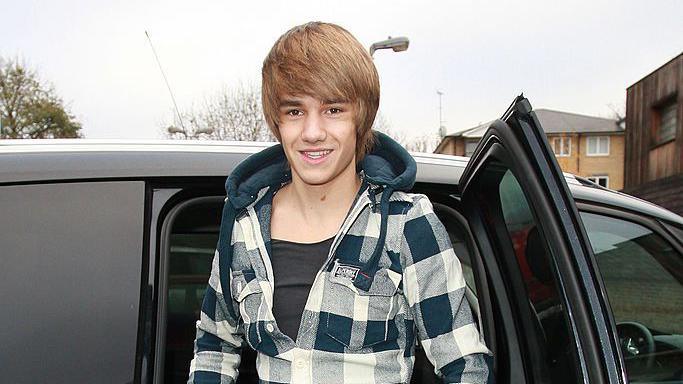 Liam Payne walks down a street 