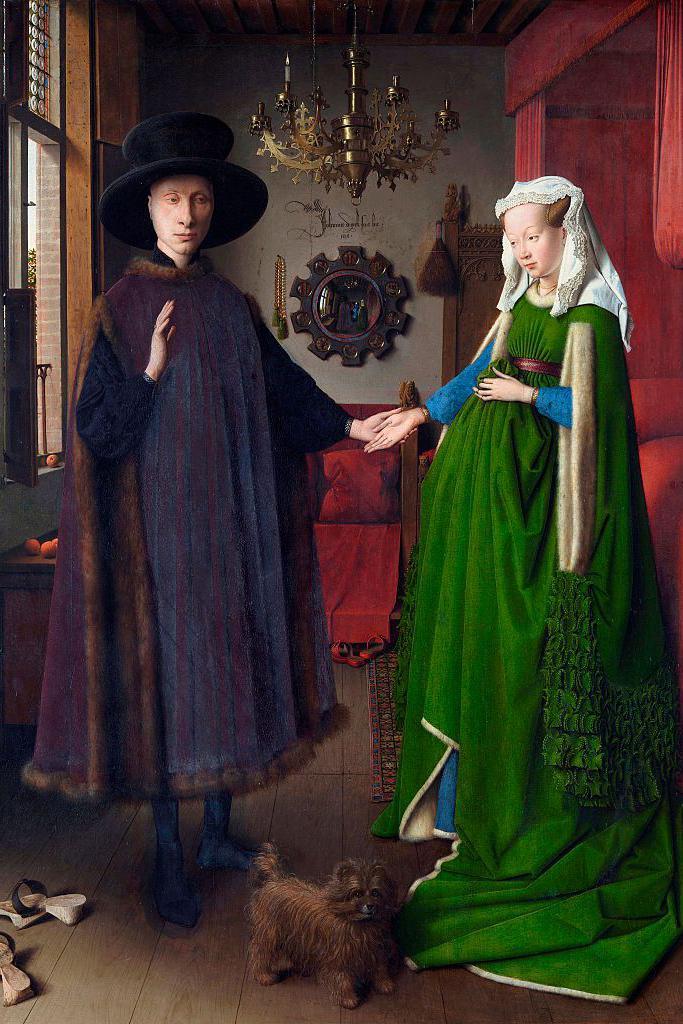 Jan Van Eyck's painting showing a man wearing a dark hat and a dark cloak-like outfit and a woman wearing a long green dress and a white head covering. They are holding hands as they stand in a room with a chandelier and mirror in the background and a small brown dog and a pair of slippers on the floor in front of them