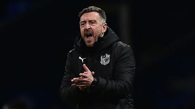 Port Vale boss Jon Brady shouts and claps at this players from the touchline during a game