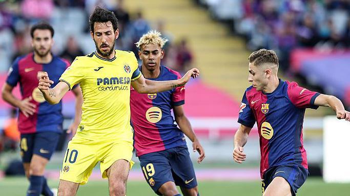 Villarreal's Dani Parejo with the ball under pressure from Barcelona's Fermin Lopez and Lamine Yamal.