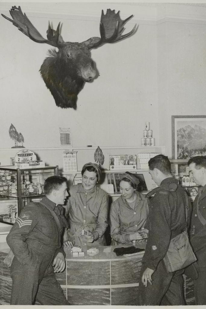 A black and white photo of three soldiers and two women at the Canadians New Beaver Club