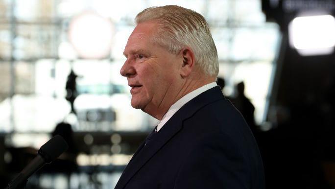 Doug Ford in suit turns his head to the side