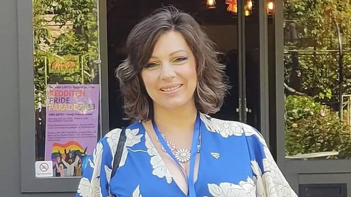 Emma Marshall in a blue and white floral top smiling at the camera