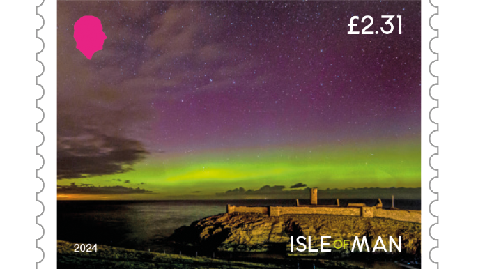 An Isle of Man £2.31 stamp with the northern lights in the sky, giving it a purple-green shade, with Peel Castle in the foreground. 