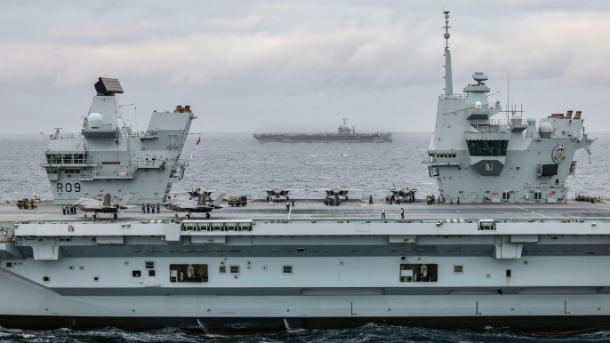 HMS Prince of Wales (foreground) with F-35B Lightning jets on deck, and USS Harry S. Truman (Background)