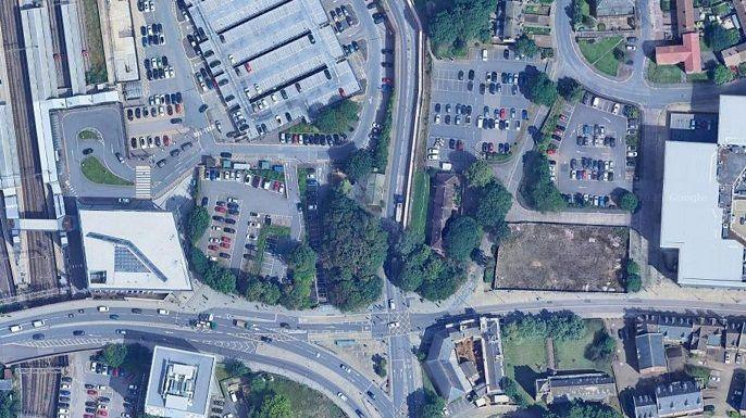 Aerial picture showing Chalk Lane Car Park, the Old Black Lion pub and St Peter's Church. Part of the car park is shielded by trees. A wide road runs across the bottom of the picture.