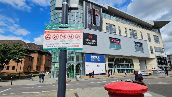 A sign in Derby City Centre which tells people about their Public Space Protection Order in front of Genting Casino. The sign says you can be fined up to £1,000 for a number of offences including drinking alcohol in public.